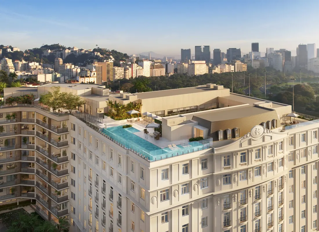 Vista aérea do Glória Residencial com a piscina de borda infinita no rooftop e a cidade ao fundo